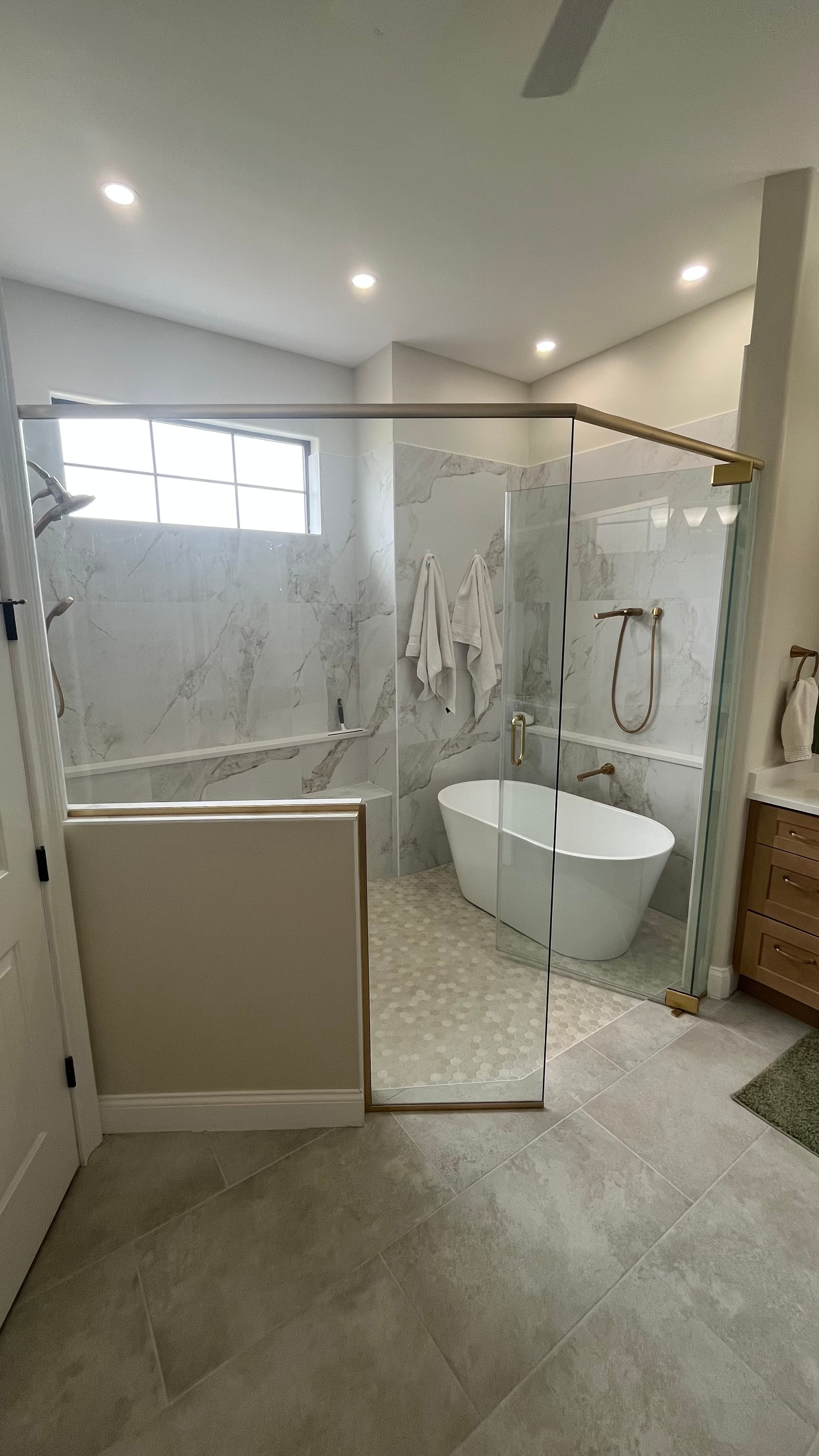Modern walk-in shower with frameless glass and wood-look tile